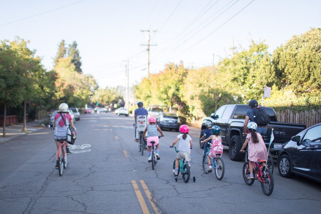 Adults and Kids ride bikes on a Slow Street