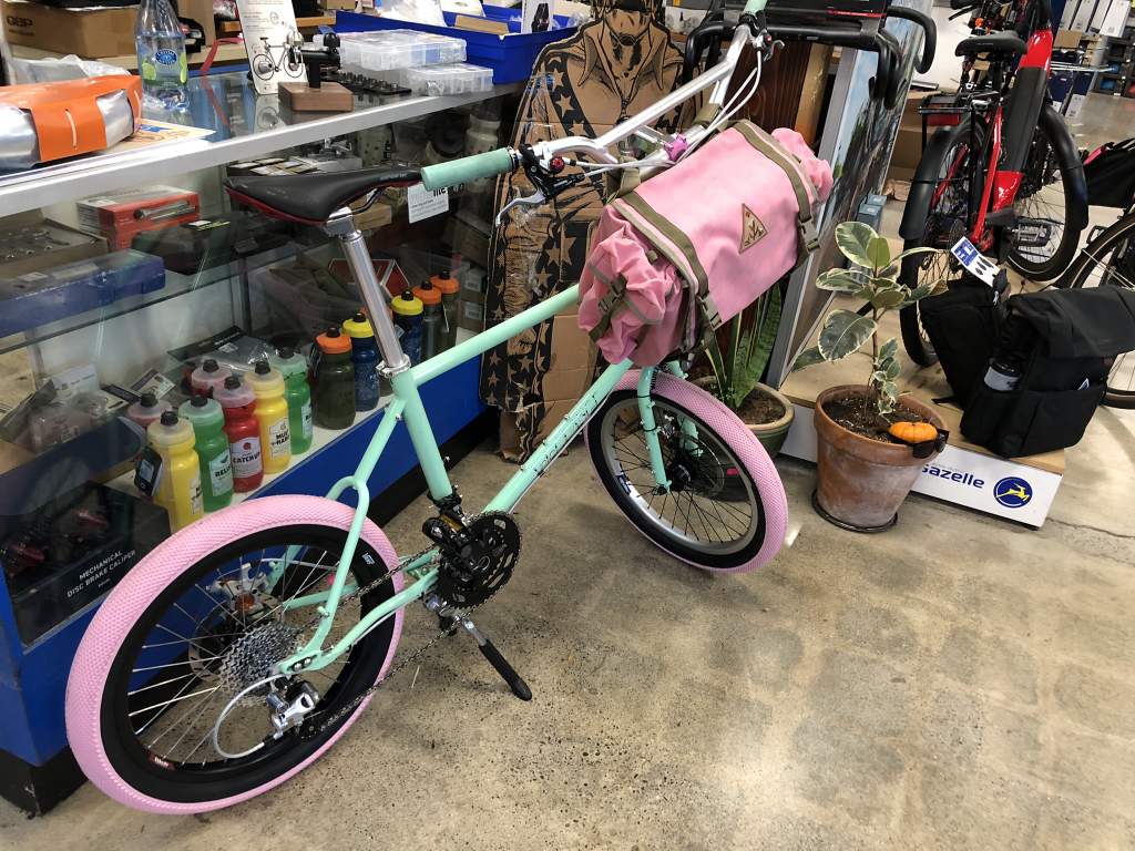 A Velo Orange MiniVelo with Pink Tires and a Pink Bag at Blue Heron Bikes in Berkeley, CA