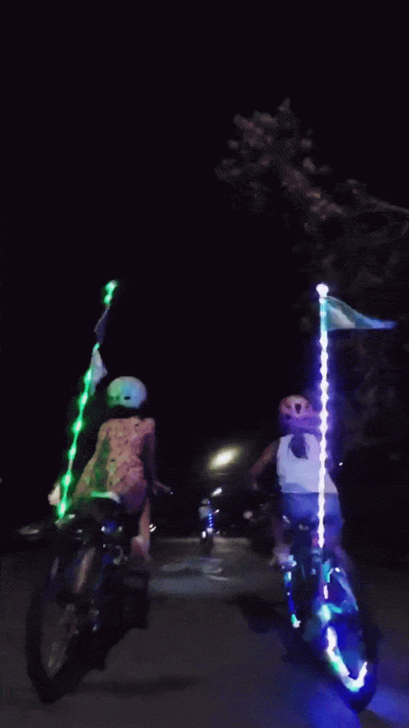 Kid riding with Bike Beam LED glow sticks / LED staff on their bicycles