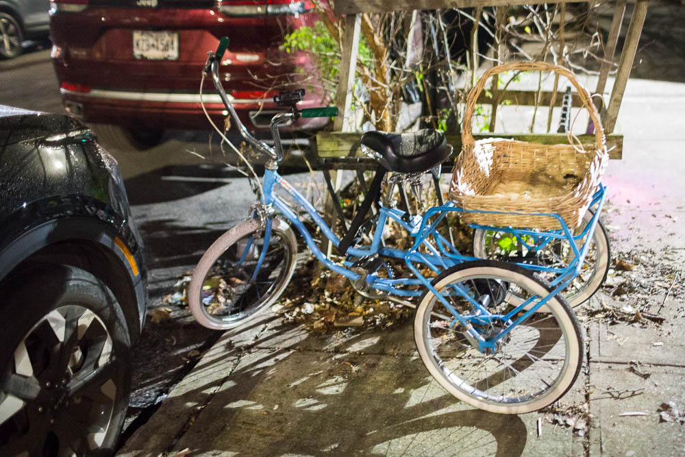 blue tricycle with wicker basket in back, in new york